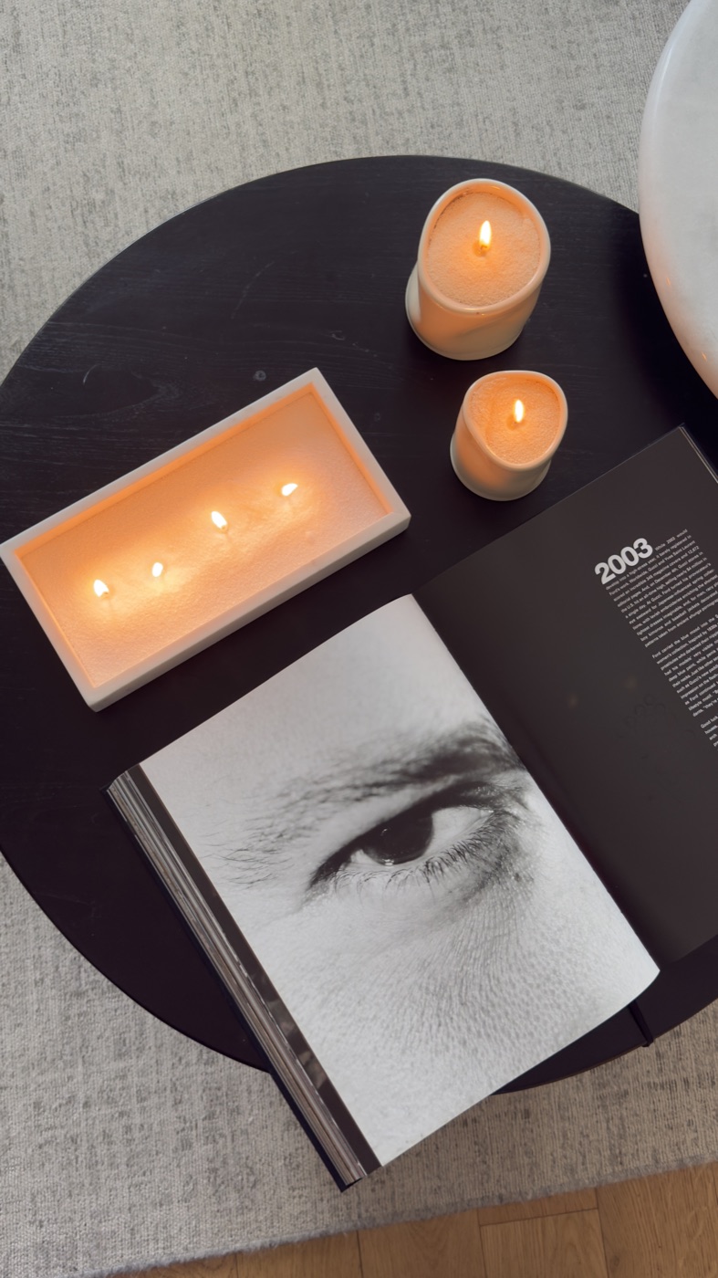 Flat-lay of lit candles and an open book on a table