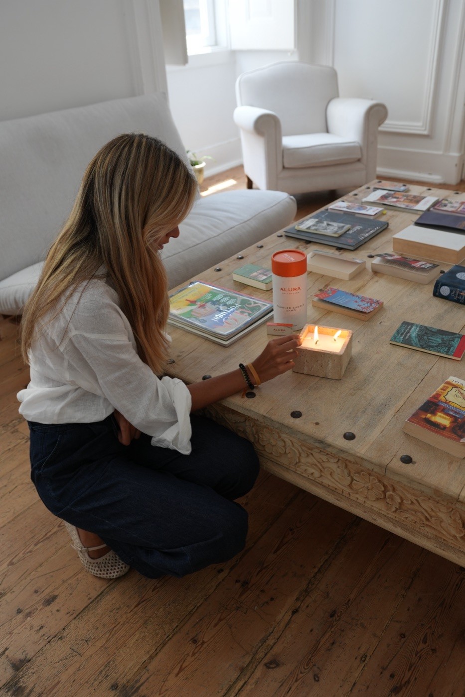 Creator lighting a candle in a styled living room